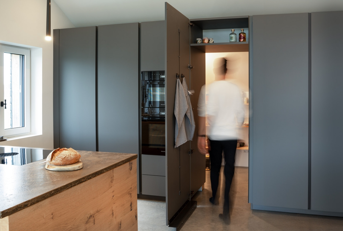 Individuelle Küchenlösung mit versteckter Speisekammer und maßgefertigten Schrankelementen von Baumann Küchen