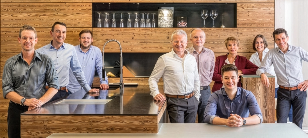 Das Team von Baumann Küchen in einer modernen Küche aus Altholz im Küchenstudio in Ebersberg bei München